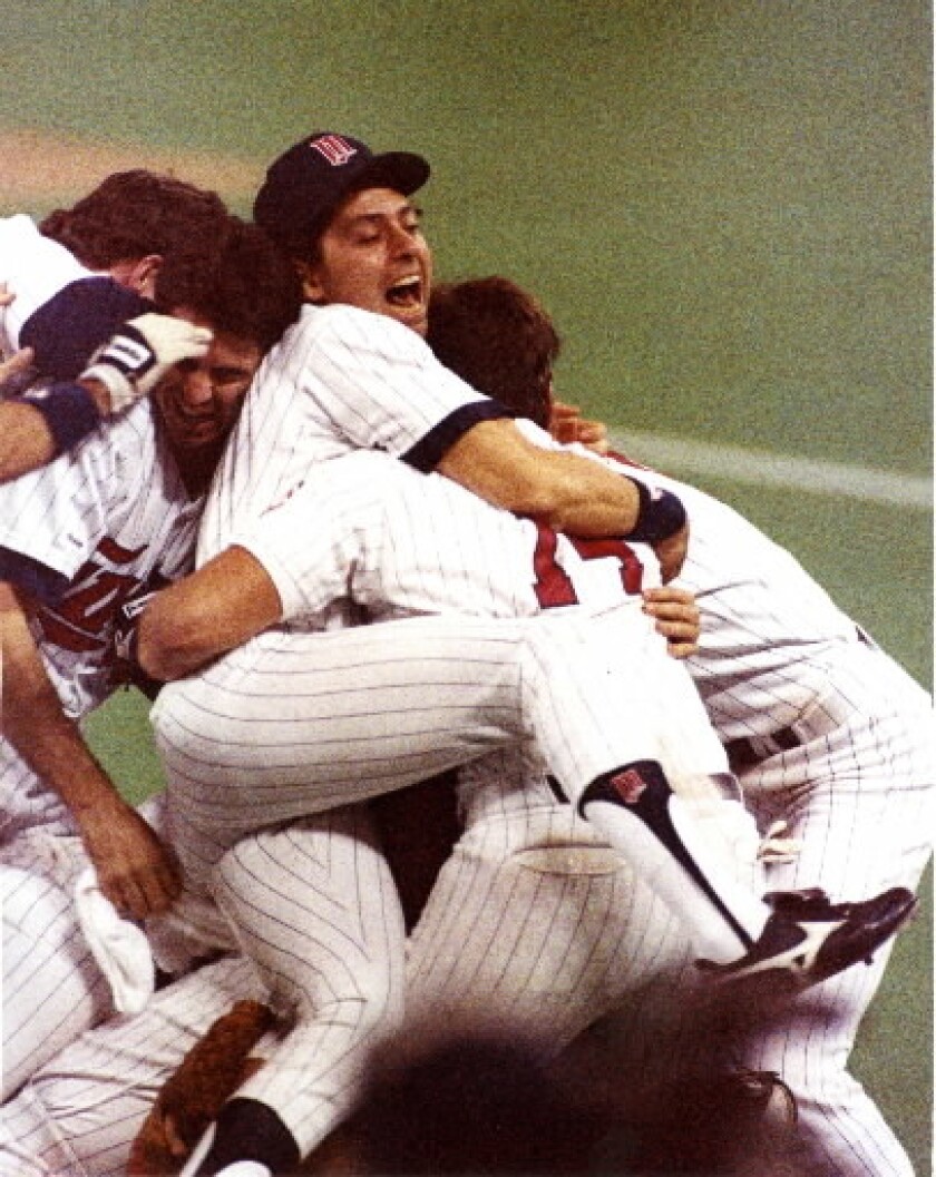 Roy Smalley III hugs teammate Kent Hrbek